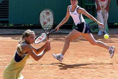 Anna Kournikova, left, of Russia, teams with Martina Hingis, of Switzerland, in their first round doubles match against Amelie Cocheteux and Alexia Dechaume-Balleret of France at the French Open at Roland Garros stadium in Paris, Thursday, May 27, 1999. (AP Photo/Laurent Rebours)